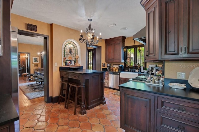 kitchen featuring dishwasher, dark countertops, a peninsula, an inviting chandelier, and pendant lighting