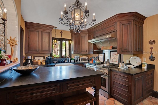 kitchen with dark countertops, a sink, ventilation hood, a chandelier, and high end stove