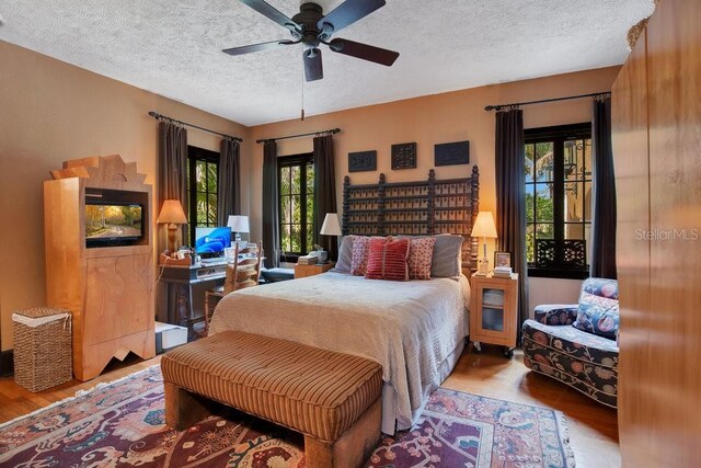 bedroom featuring a textured ceiling, ceiling fan, and wood finished floors