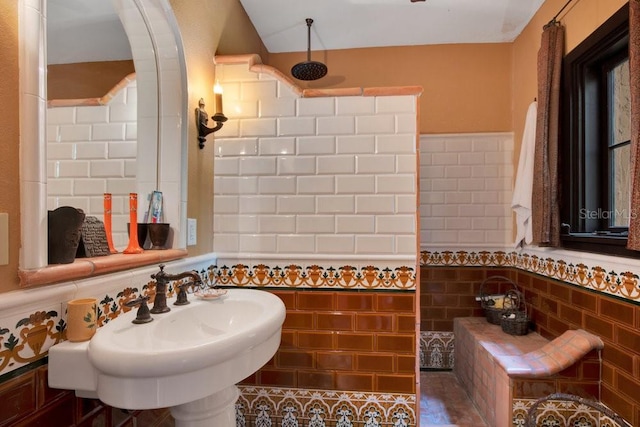 full bath with a sink, walk in shower, tile walls, and wainscoting