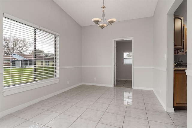 unfurnished room with a sink, light tile patterned floors, baseboards, and a notable chandelier