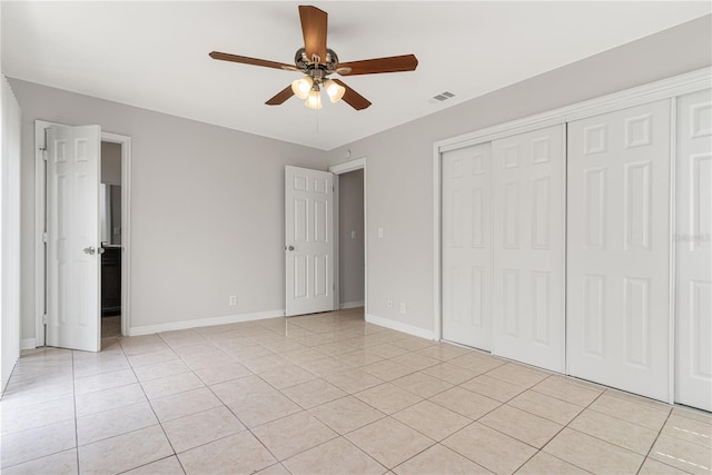 unfurnished bedroom with light tile patterned floors, baseboards, visible vents, and a closet