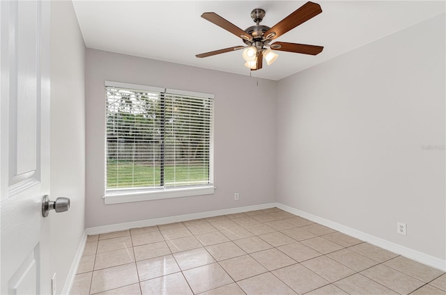 spare room with a healthy amount of sunlight, light tile patterned floors, ceiling fan, and baseboards