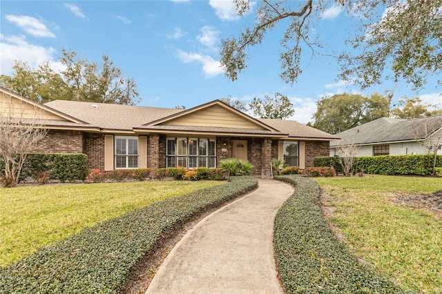 ranch-style house featuring a shingled roof, brick siding, and a front lawn