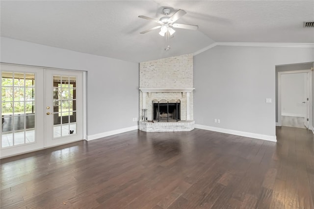 unfurnished living room with dark wood-type flooring, vaulted ceiling, a textured ceiling, french doors, and a fireplace