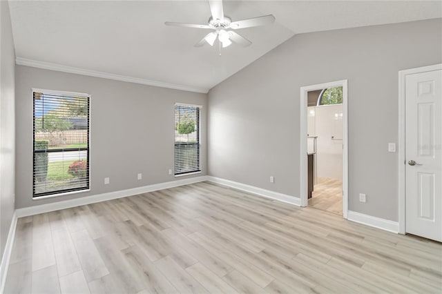 spare room with lofted ceiling, light wood-type flooring, a wealth of natural light, and baseboards