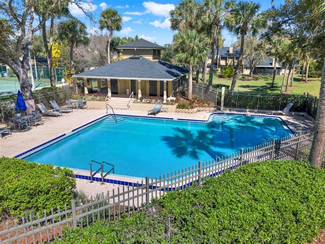 pool with a patio and fence