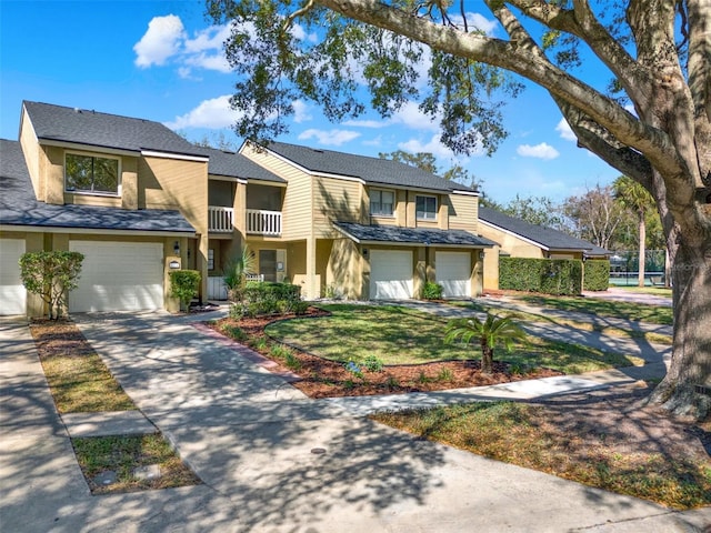 multi unit property with driveway, an attached garage, and stucco siding