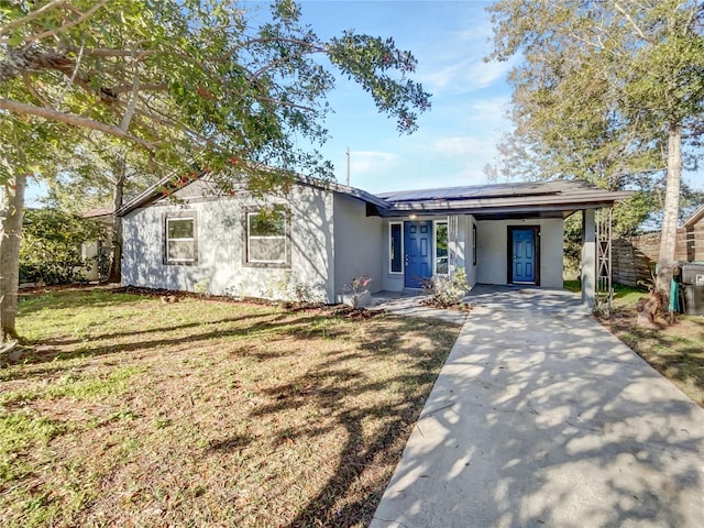 view of front of home with a carport, a front yard, concrete driveway, and stucco siding