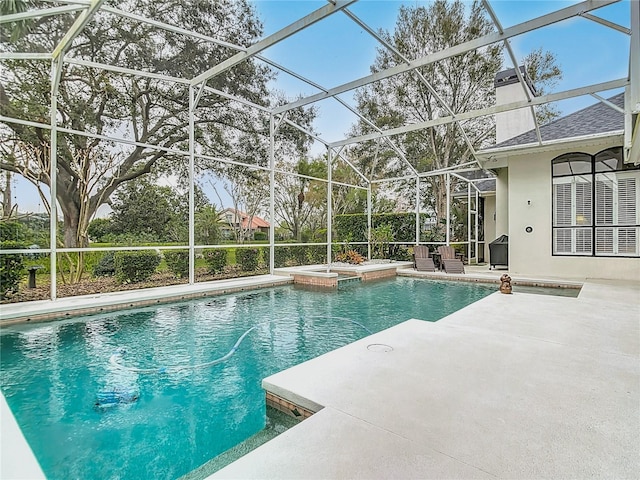 view of swimming pool with a lanai, a pool with connected hot tub, and a patio