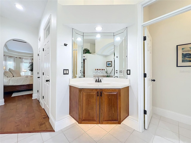 ensuite bathroom featuring tile patterned flooring, vanity, baseboards, and ensuite bathroom