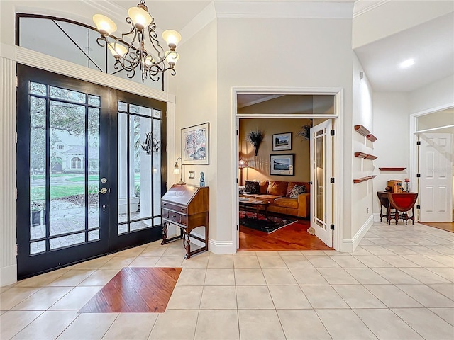 tiled foyer with baseboards, ornamental molding, and french doors