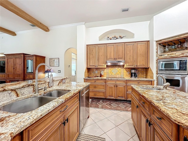 kitchen featuring under cabinet range hood, a sink, visible vents, appliances with stainless steel finishes, and decorative backsplash