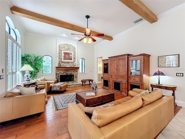 living room with beamed ceiling, a fireplace, visible vents, and crown molding