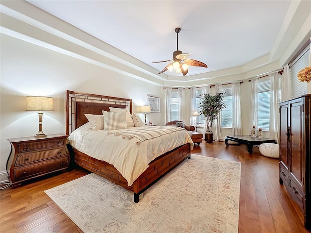 bedroom featuring a ceiling fan, a raised ceiling, and hardwood / wood-style floors