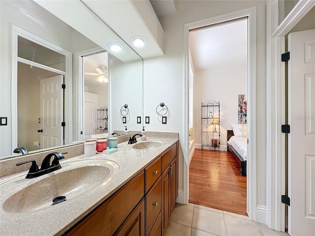 full bath with double vanity, ensuite bath, a sink, and tile patterned floors