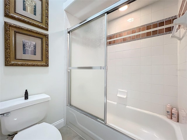 bathroom featuring toilet and combined bath / shower with glass door