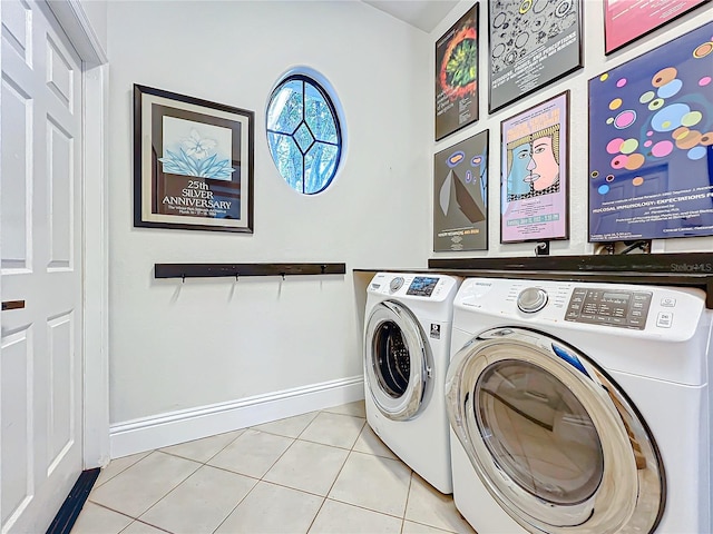 laundry room with laundry area, light tile patterned flooring, washing machine and dryer, and baseboards