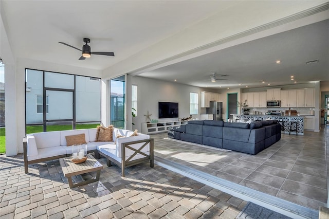 living area featuring visible vents, a ceiling fan, and recessed lighting