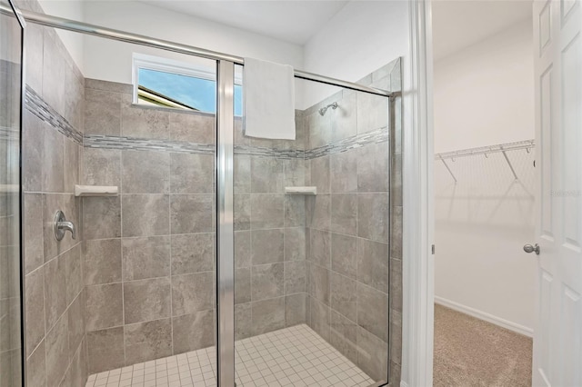 bathroom featuring a shower stall and a spacious closet