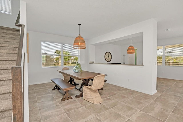 dining space with a wealth of natural light, baseboards, and stairs