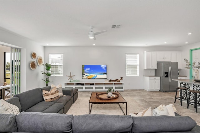 living room featuring a ceiling fan, visible vents, and recessed lighting