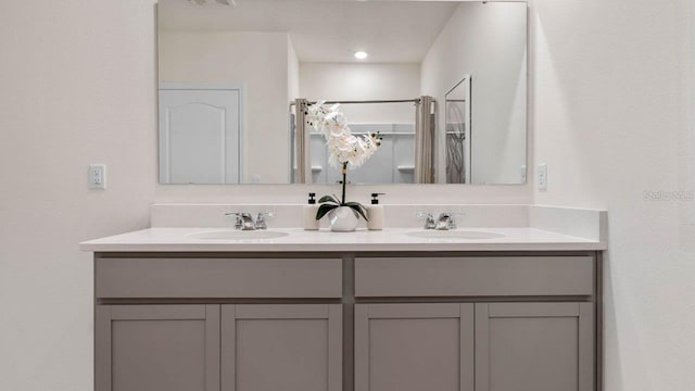 bathroom featuring double vanity, curtained shower, and a sink