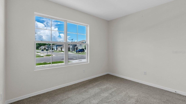 empty room featuring carpet flooring and baseboards