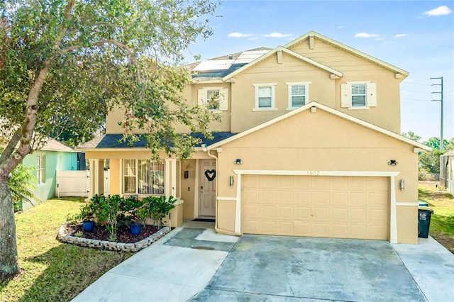 view of front facade featuring driveway, an attached garage, fence, and stucco siding