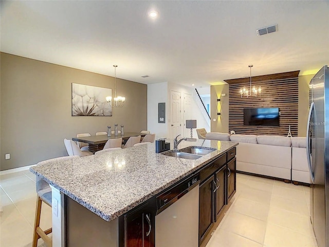 kitchen featuring a chandelier, stainless steel appliances, hanging light fixtures, and a sink