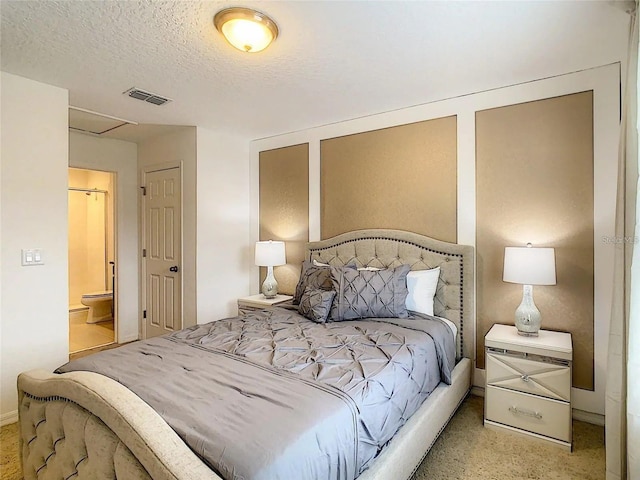 bedroom with ensuite bath, visible vents, a textured ceiling, and light colored carpet