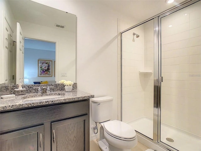 bathroom featuring toilet, a shower stall, visible vents, and vanity