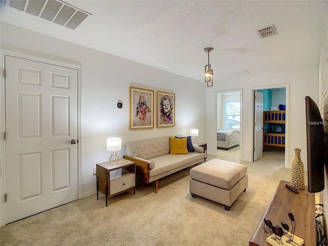 living area with light carpet, baseboards, visible vents, and a textured ceiling