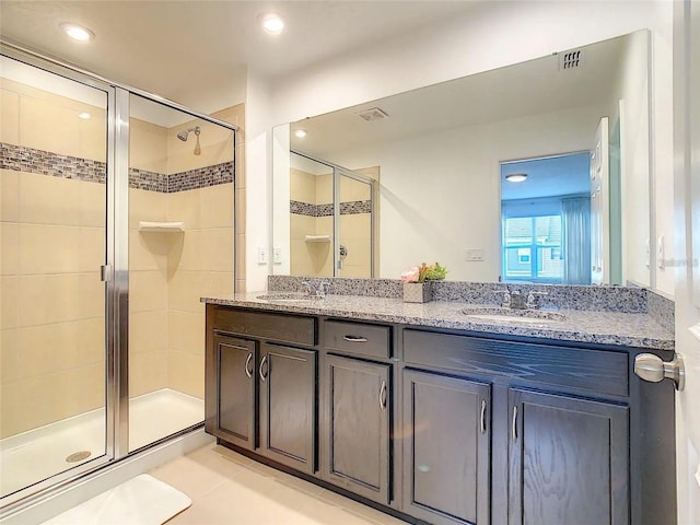 bathroom with tile patterned flooring, a sink, visible vents, a shower stall, and double vanity