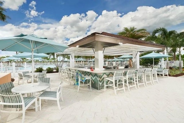 view of patio / terrace with exterior bar and fence