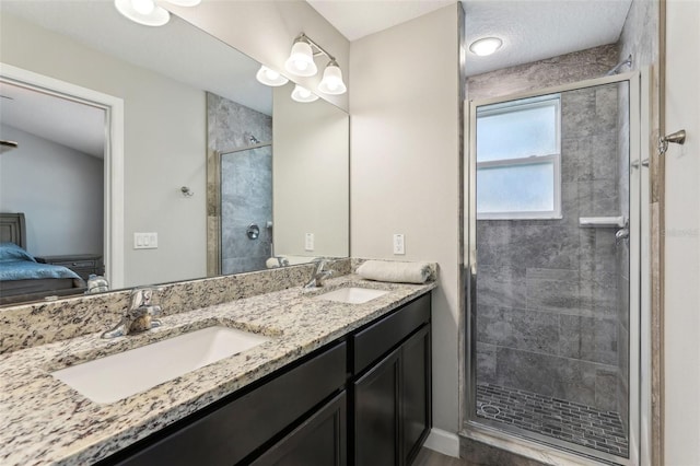 ensuite bathroom featuring a stall shower, a sink, ensuite bath, and double vanity