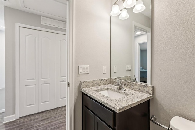 bathroom featuring a closet, visible vents, vanity, and wood finished floors