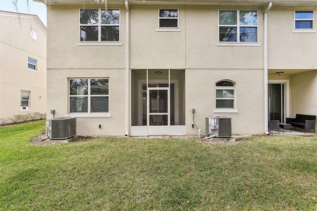 back of property featuring cooling unit, a yard, and stucco siding