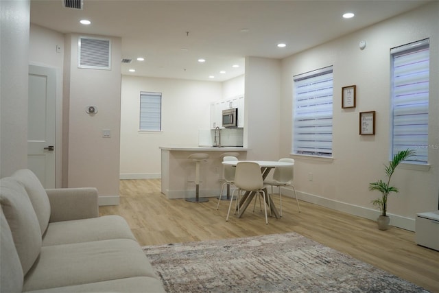 interior space with baseboards, light wood-type flooring, visible vents, and recessed lighting