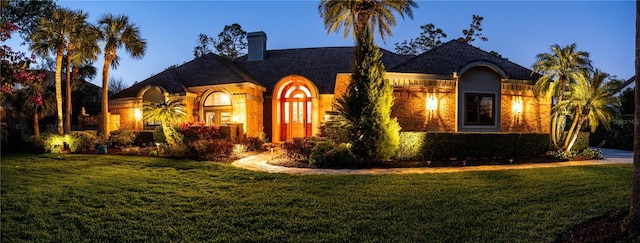 view of front of home featuring a chimney and a front yard