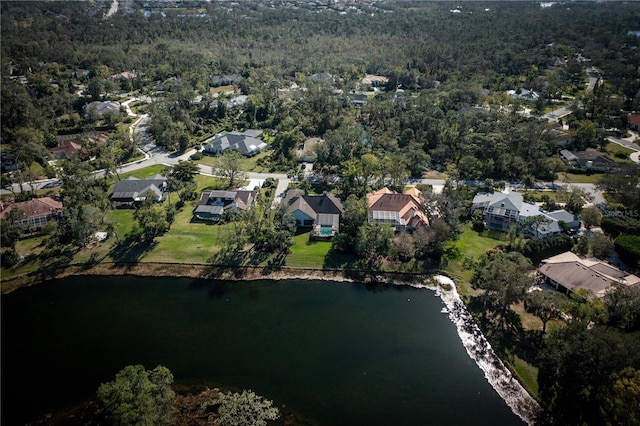 bird's eye view featuring a residential view, a water view, and a wooded view