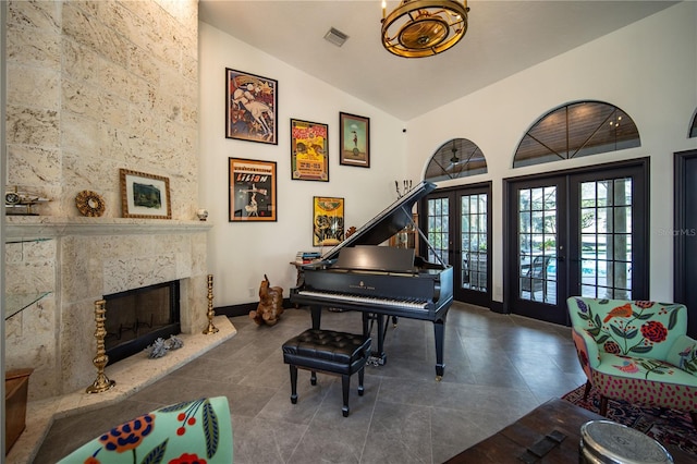 living area featuring french doors, a fireplace, visible vents, high vaulted ceiling, and dark tile patterned flooring