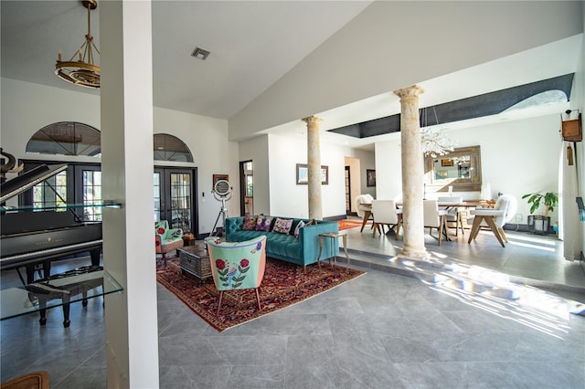 living area with high vaulted ceiling, french doors, visible vents, and decorative columns