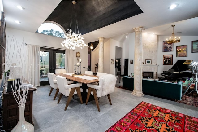 dining area featuring ornate columns, a fireplace, vaulted ceiling, and french doors