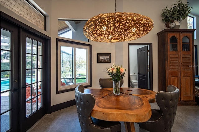 dining space featuring dark tile patterned floors and baseboards