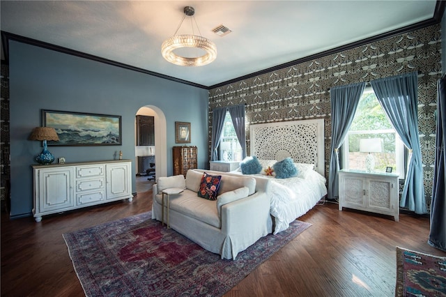 bedroom with dark wood-style floors, multiple windows, arched walkways, and ornamental molding