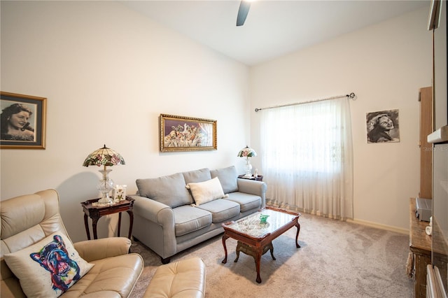 carpeted living area with a ceiling fan and baseboards