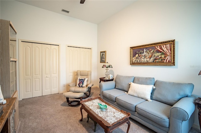 living area featuring high vaulted ceiling, carpet flooring, and visible vents