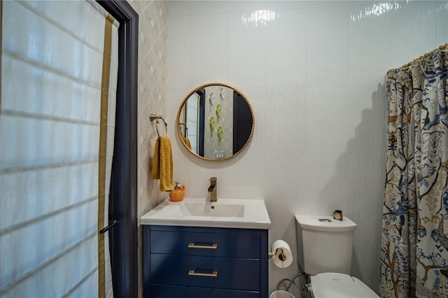 bathroom featuring tile walls, vanity, and toilet