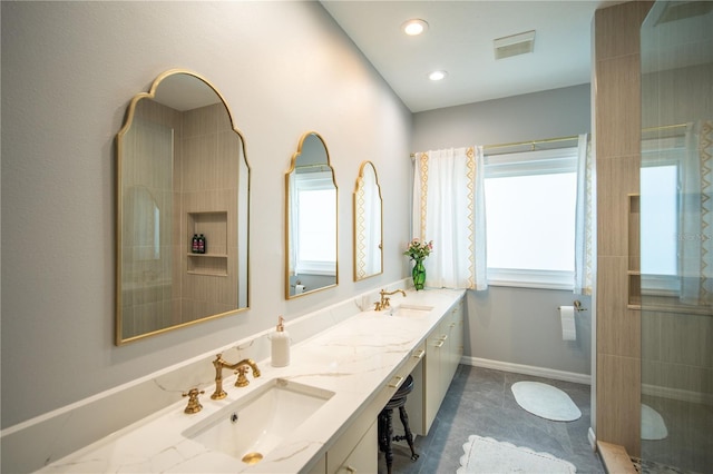 bathroom featuring double vanity, a sink, visible vents, and baseboards